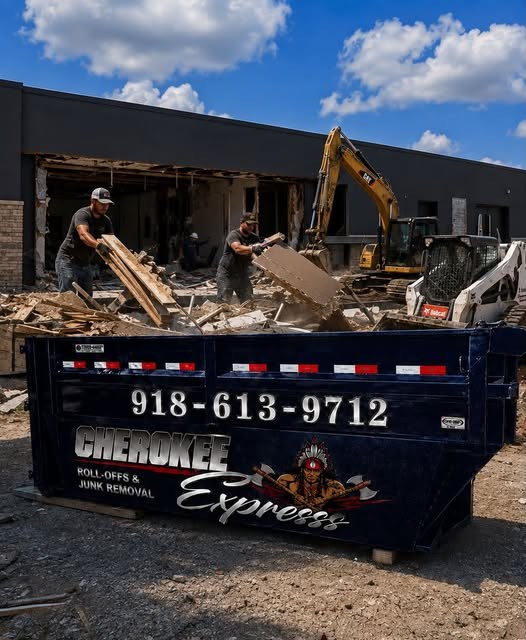 Cherokee Express dumpster on a commercial demolition site with crew loading debris